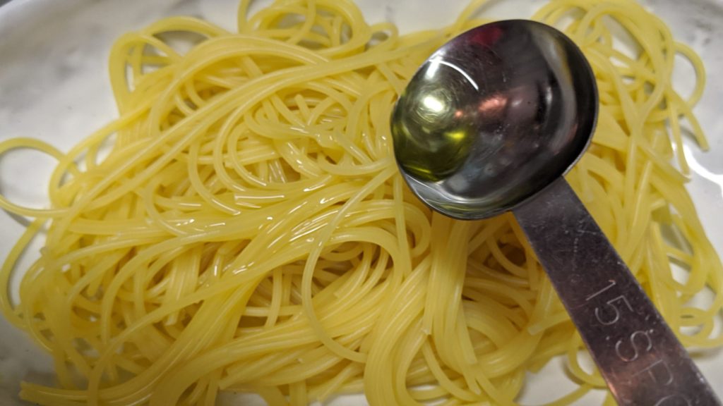 パスタにオリーブオイルをかける