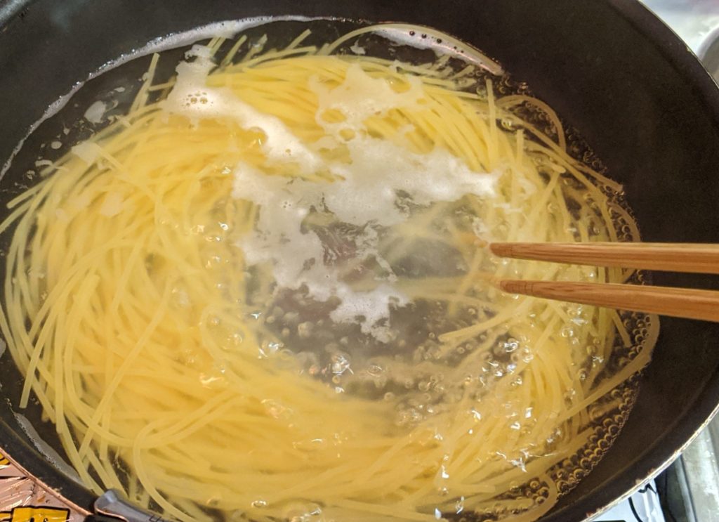 スパゲティを鍋で茹でる