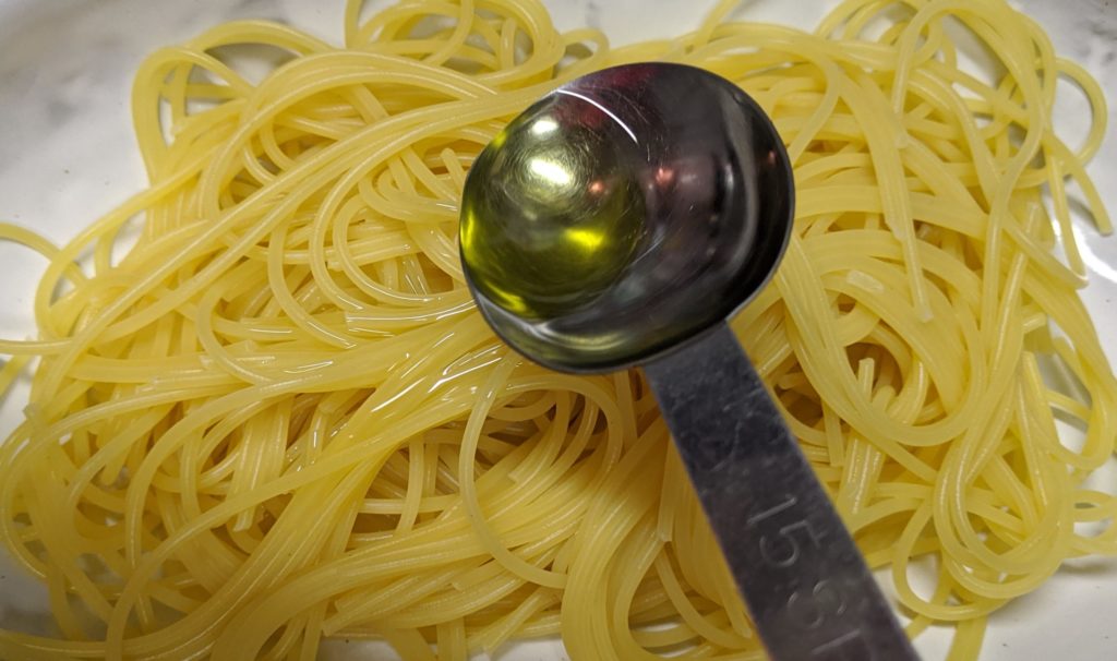 スパゲティにオリーブオイルをあえる